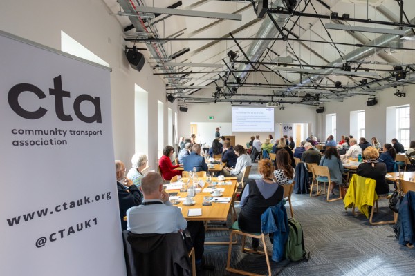 photo showing a room of people looking a projector slide with a cta pop up banner on the left. 