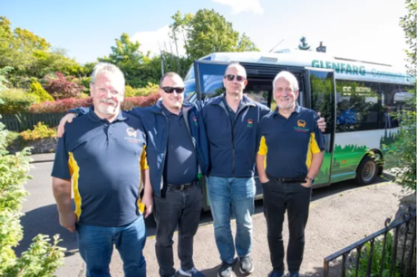 staff from Glenfarg community transport in blue polo shirts, standing in front of their mini bus