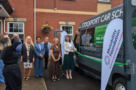 photo showing staff from stockport community transport car scheme posing for a photo in front of a minibus