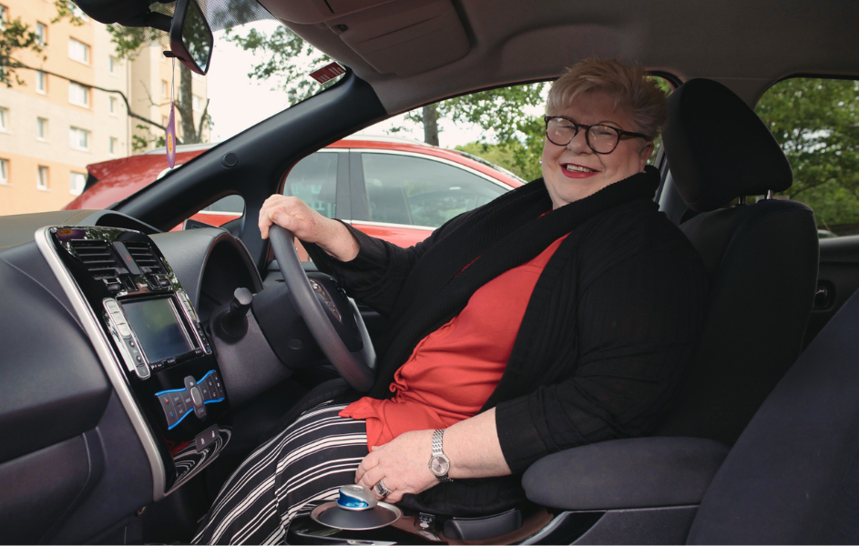 A woman sits behind the wheel of a car