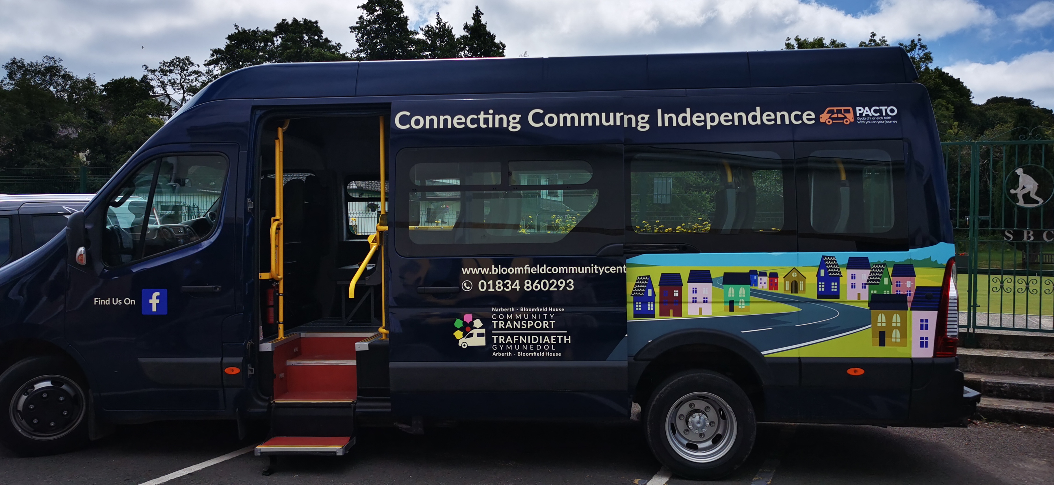 Navy PACTO community transport vehicle with colourful branding on the side of it