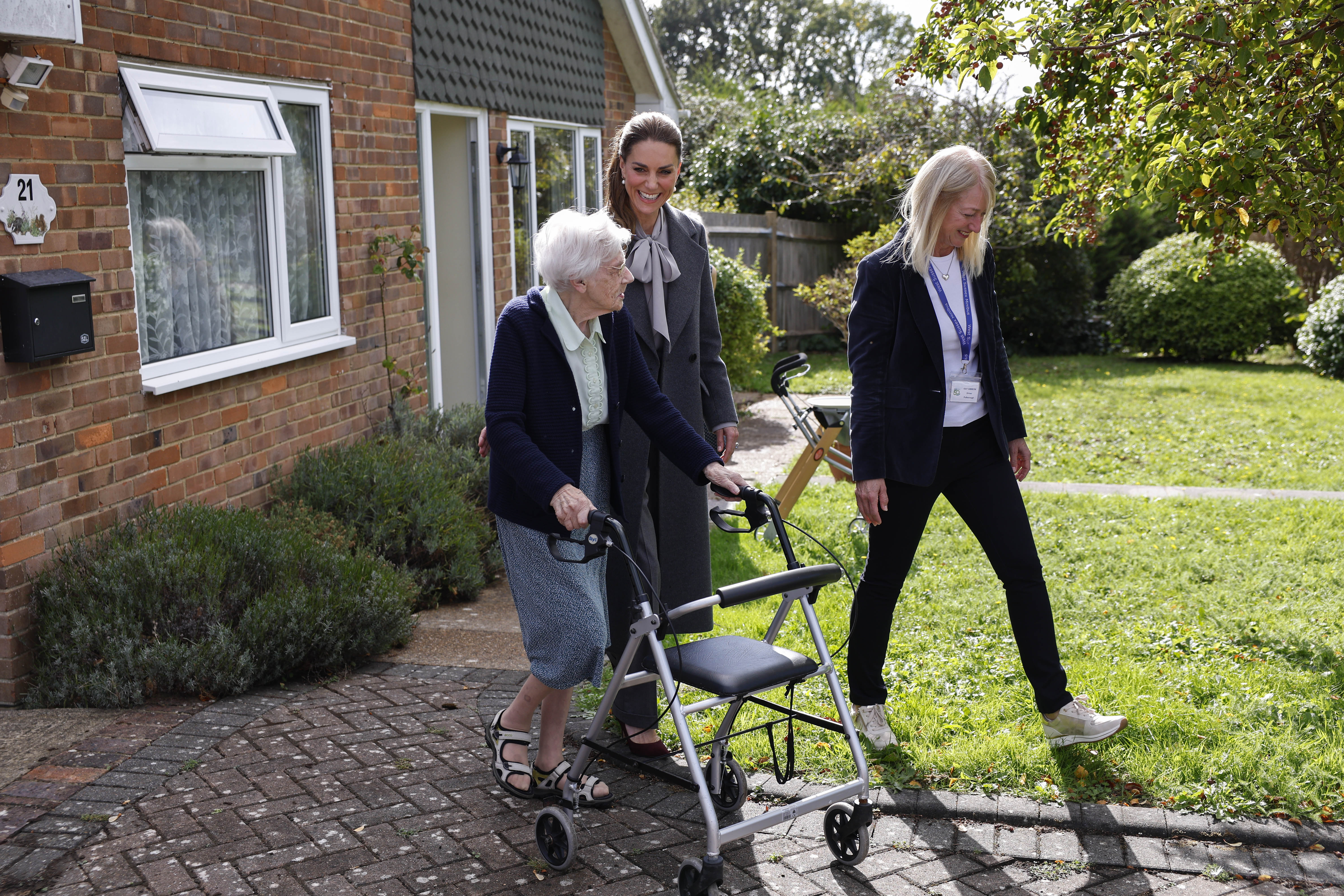 The Princess of Wales walking alongside her assistant and a service-user who has been picked up at her house by the minibus