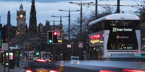 city scape with clock tower and double decker bus