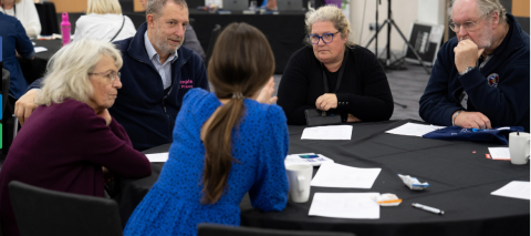 people sat around a conference table talking