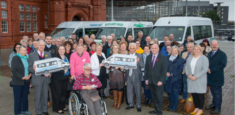 photo of a group of volunteers in front of vehicles, smiling