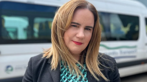 Director for Training and Northern Ireland, Noeleen Lynch standing in front of a minibus