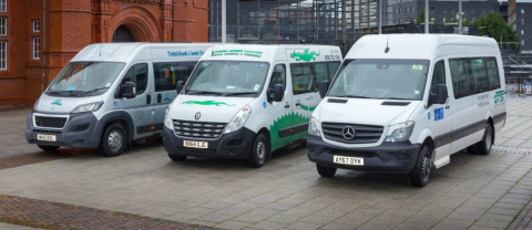 photo shows three minibuses in front of a brick built building