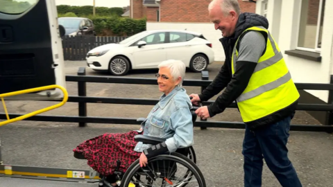 Patricia is guided onto a Community Transport vehicle