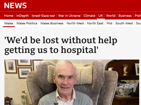 Screen shot of bbc wales news page. Red banner, white and black text and a photo of a bus passenger, male, in a grey cardigan sitting in an armchair. 