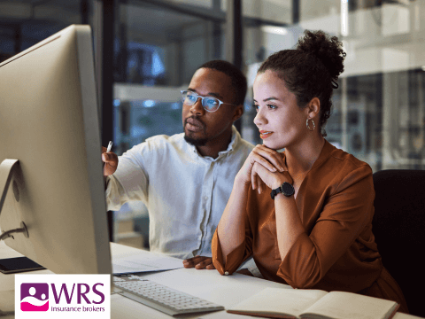 a man and woman look at a computer 