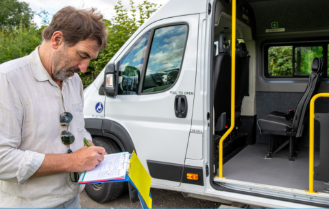 A man stands by a minibus