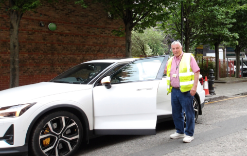 a man in high vis stands by a car
