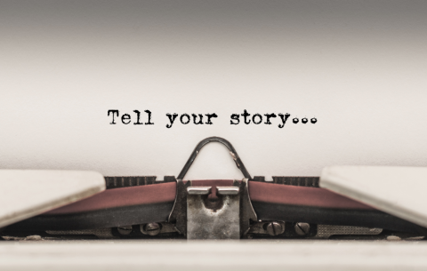 Paper in a typewriter reads 'Tell your story'