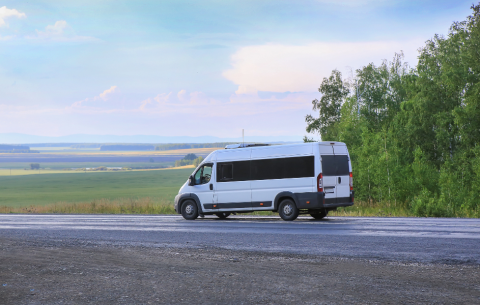 Image of a white minibus driving on the road