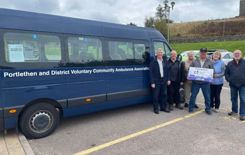 An image of various people standing outside a navy Portlethen and District Voluntary Community Ambulance