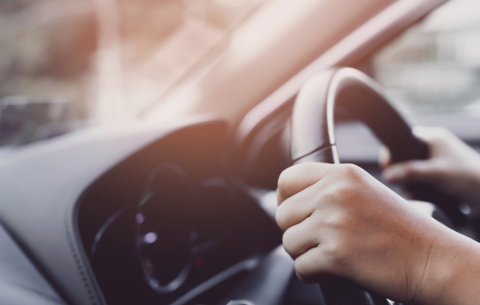 a person with their hands on the steering wheel