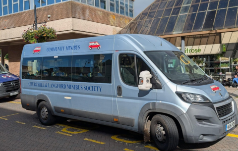 Silver CLMS Community Minibus vehicle parked outside with branding on the side