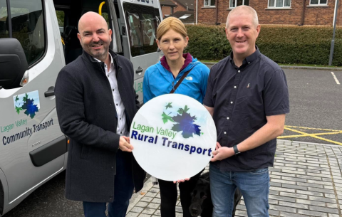 Sharon Gordon and her now-retired guide dog Alfie (middle), pictured with David Honeyford MLA (left) and Richard Dougherty, Manager of Lagan Valley Rural Transport (right), celebrating CT Week 2025. 