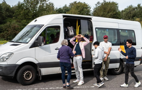 A group of people getting on a community bus