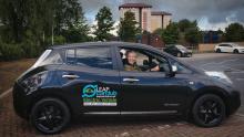 dark blue car with Leap signage and woman smiling in drivers seat 