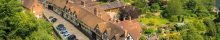 photo of tudor styles houses and cars parked outside, surrounded by trees and greenery