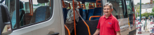 man in red shirt boarding an accessible grey minibus 