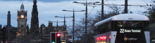 city scape with clock tower and double decker bus