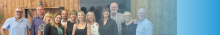 wood paneled room with group of smiling people from Northern Ireland smiling at the camera 