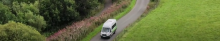 white mini bus driving through the countryside 